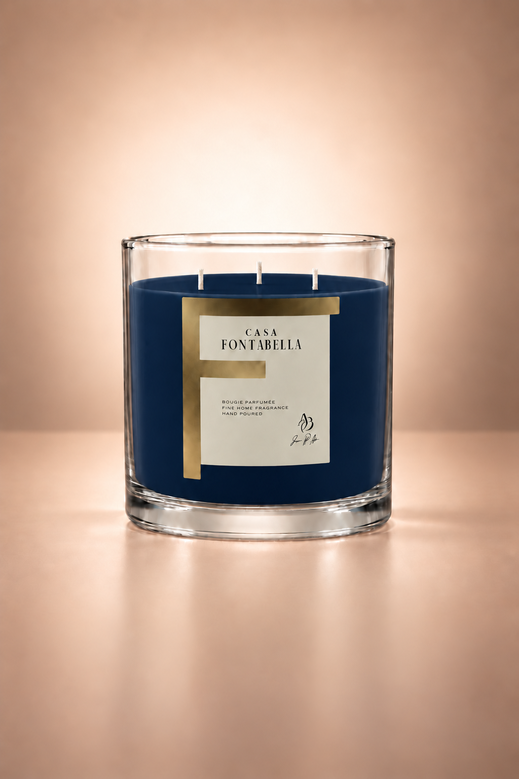 Vela aromática de Casa Fontabella en frasco Mónaco transparente con cera en tono azul rey, encendida — cera de soya y coco con tres mechas de algodón.