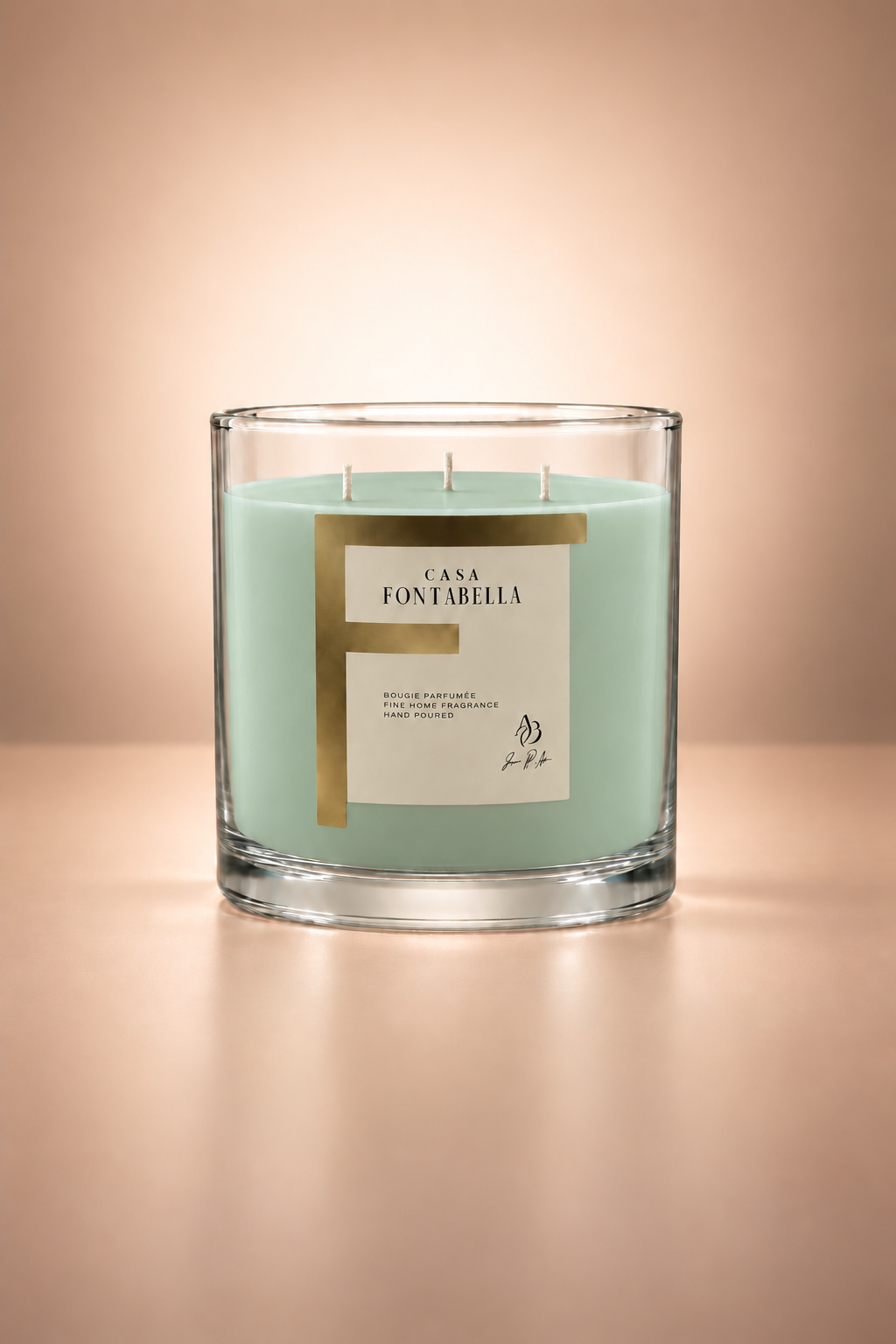 Vela aromática de Casa Fontabella en frasco Mónaco transparente con cera en tono espuma de mar, encendida — cera de soya y coco con tres mechas de algodón.