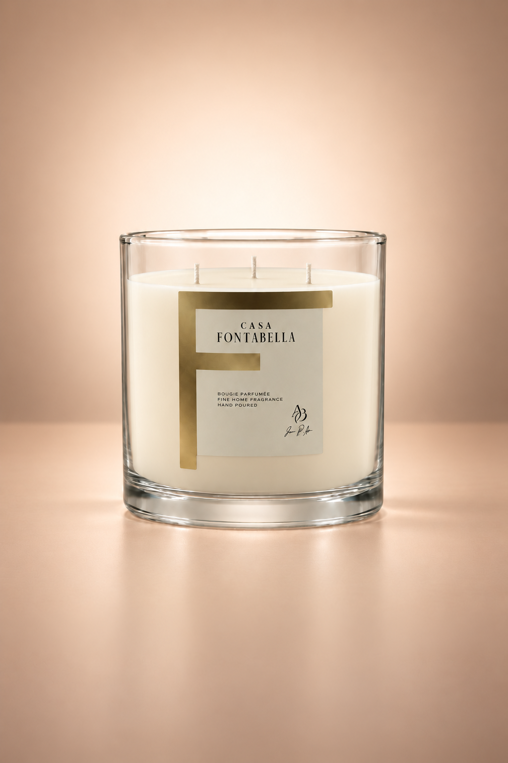 Vela aromática de Casa Fontabella en frasco Mónaco transparente con cera en su tono natural sin teñir, encendida — cera de soya y coco con tres mechas de algodón.