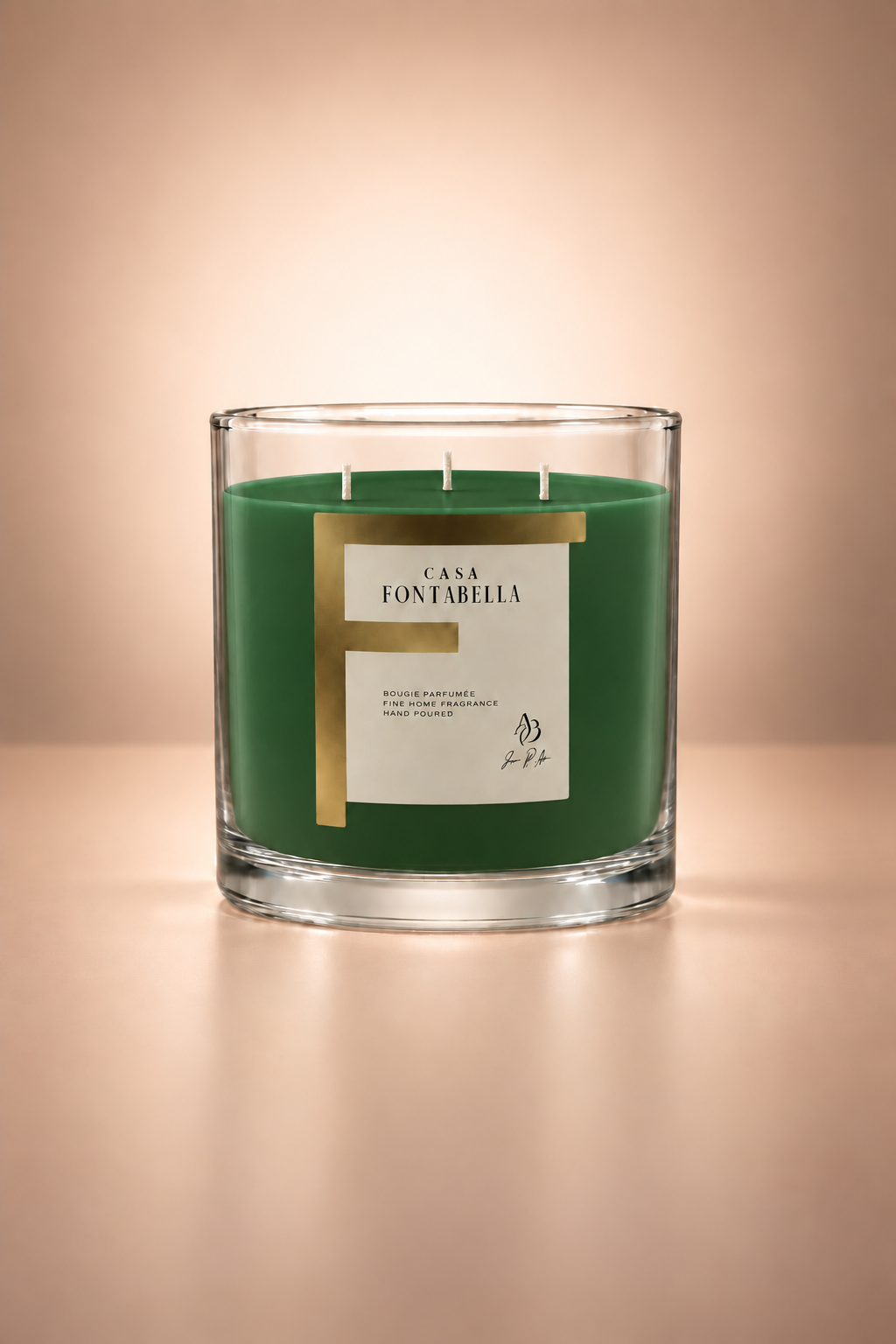 Vela aromática de Casa Fontabella en frasco Mónaco transparente con cera en tono verde, encendida — cera de soya y coco con tres mechas de algodón.
