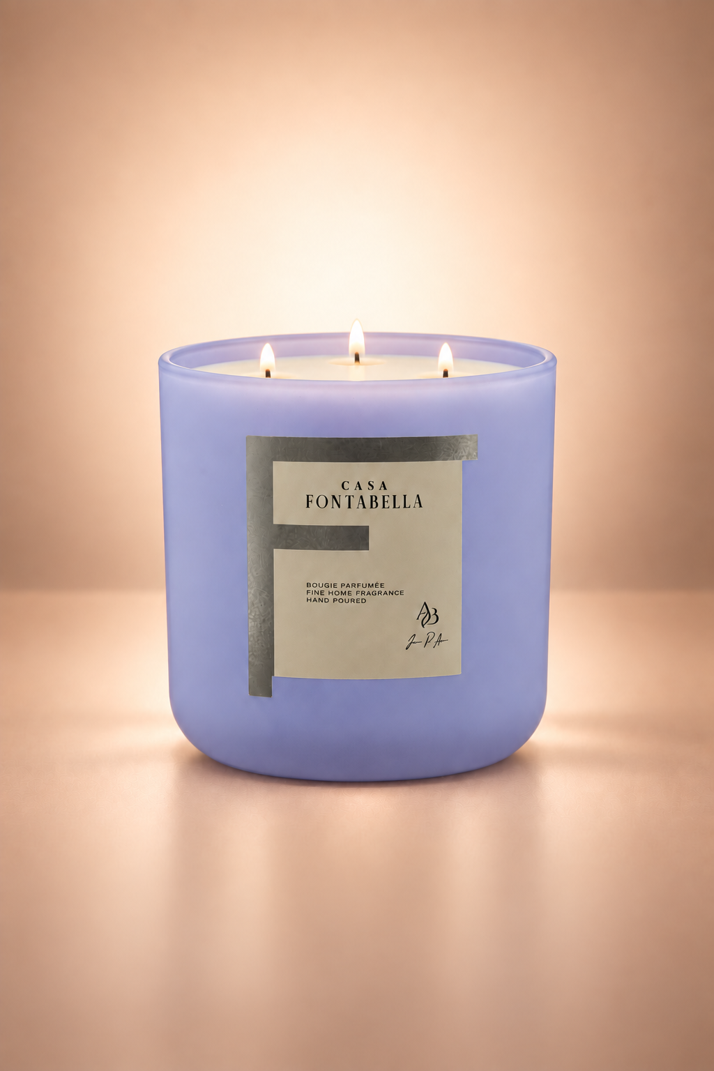 Vela aromática de Casa Fontabella en frasco Valencia azul bebé mate, encendida — cera de soya y coco con tres mechas de algodón.