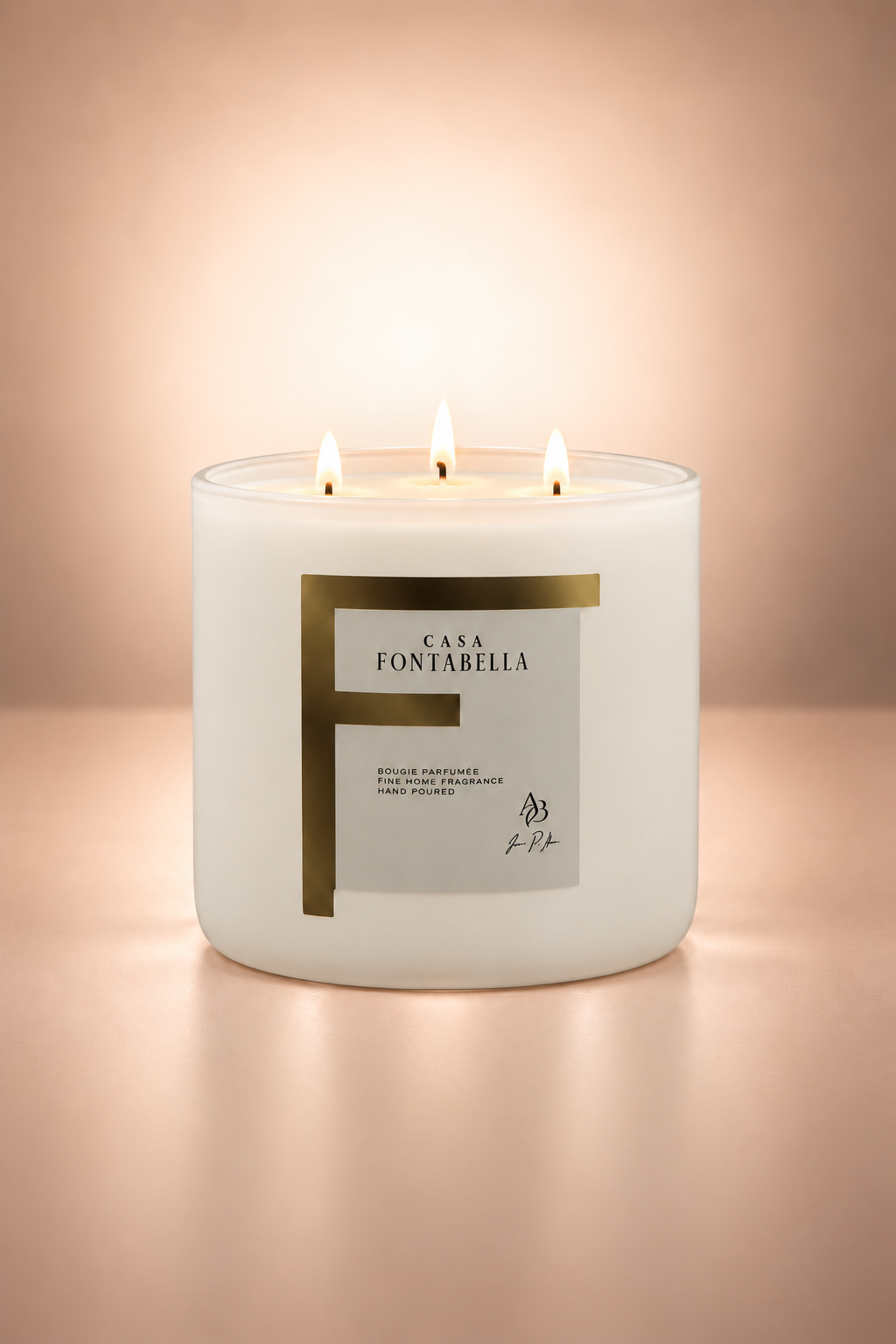 Vela aromática de Casa Fontabella en frasco Mónaco blanco beige, encendida — cera de soya y coco con tres mechas de algodón.