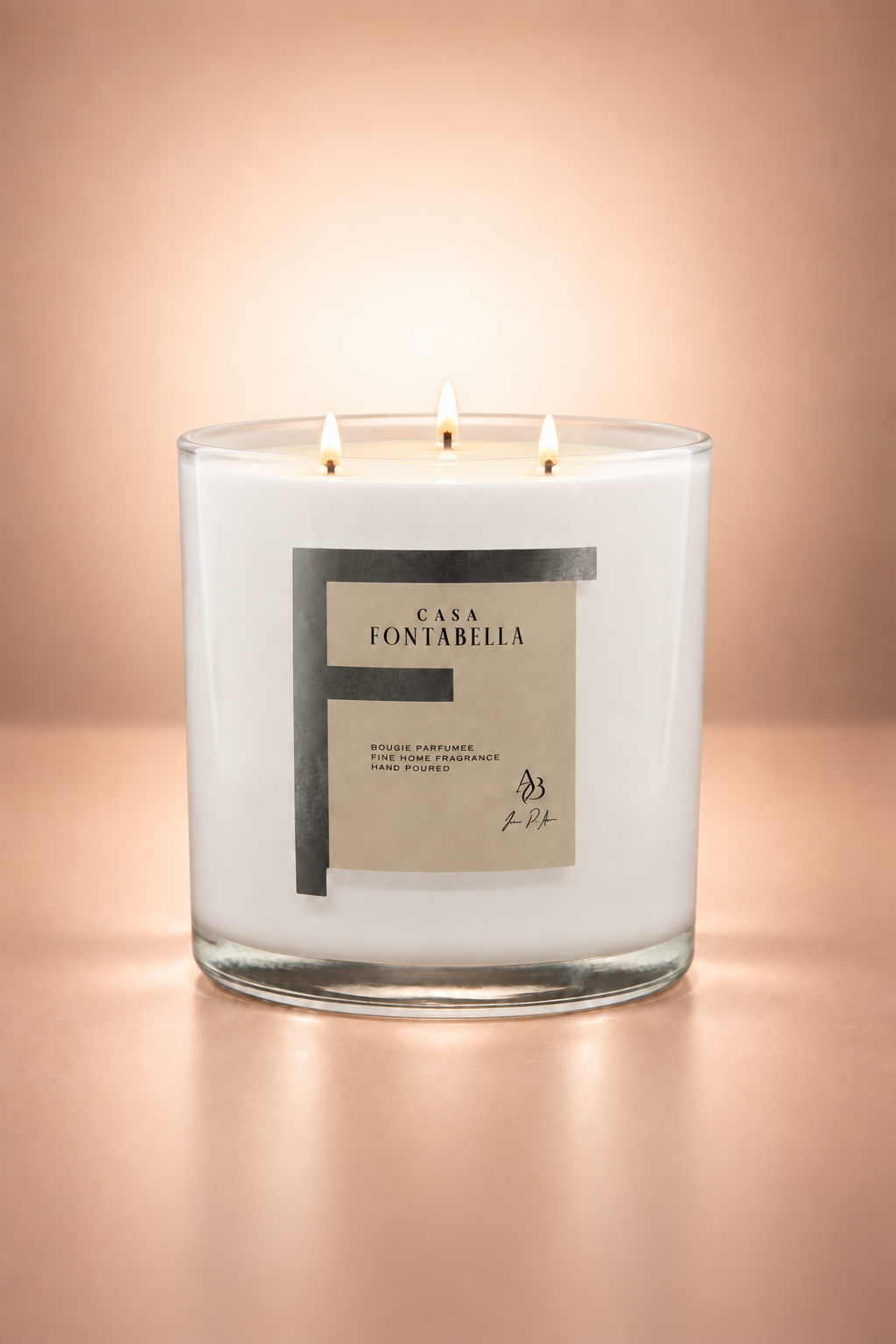 Vela aromática de Casa Fontabella en frasco Mónaco blanco brillante, encendida — cera de soya y coco con tres mechas de algodón.