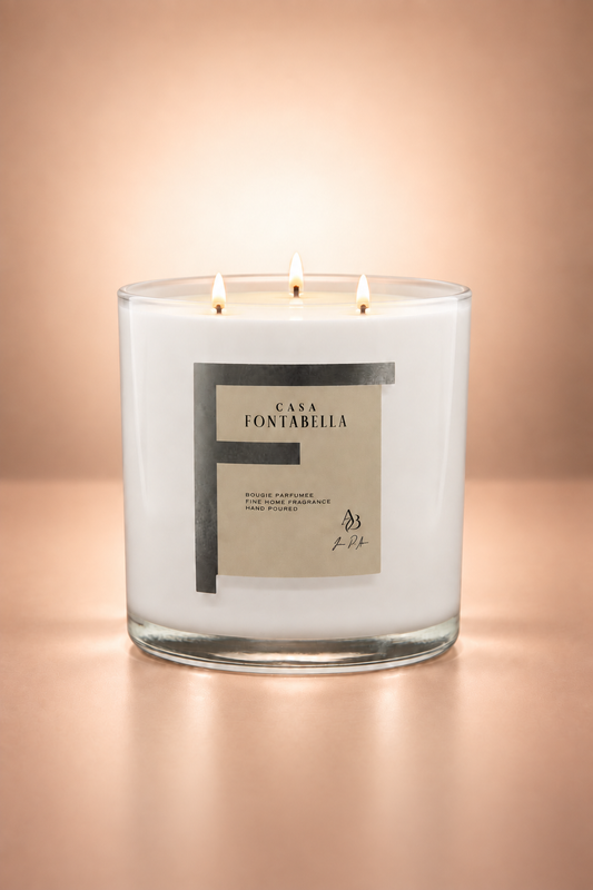 Vela aromática de Casa Fontabella en frasco Mónaco blanco brillante, encendida — cera de soya y coco con tres mechas de algodón.