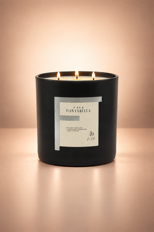 Vela aromática de Casa Fontabella en frasco Mónaco negro mate con detalle plata, encendida — cera de soya y coco con tres mechas de algodón.