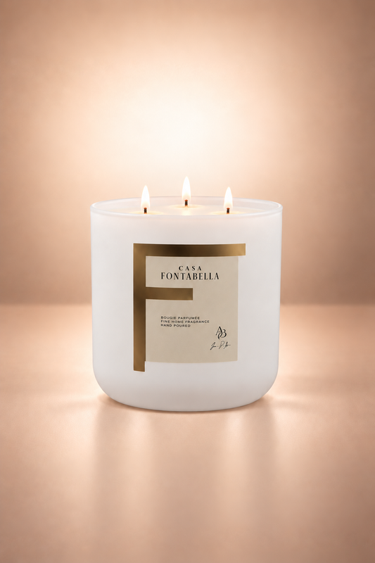 Vela aromática de Casa Fontabella en frasco Valencia blanco mate de base redonda, encendida — cera de soya y coco con tres mechas de algodón.
